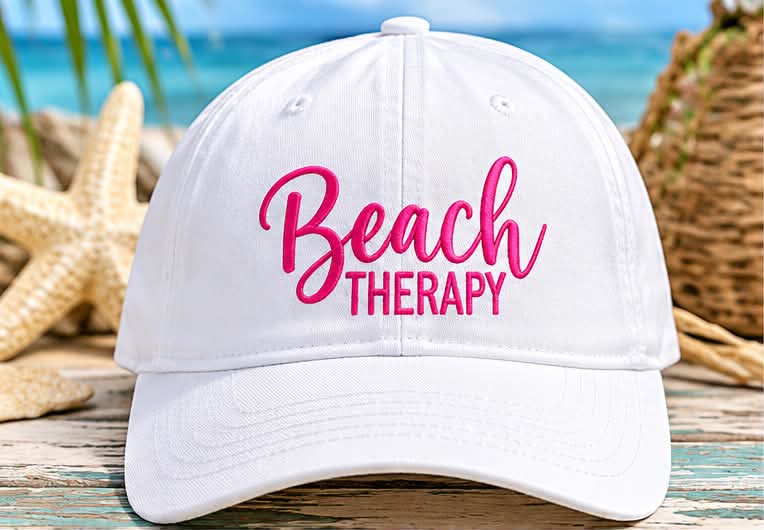 White ball cap embroidered with Beach Therapy in pink