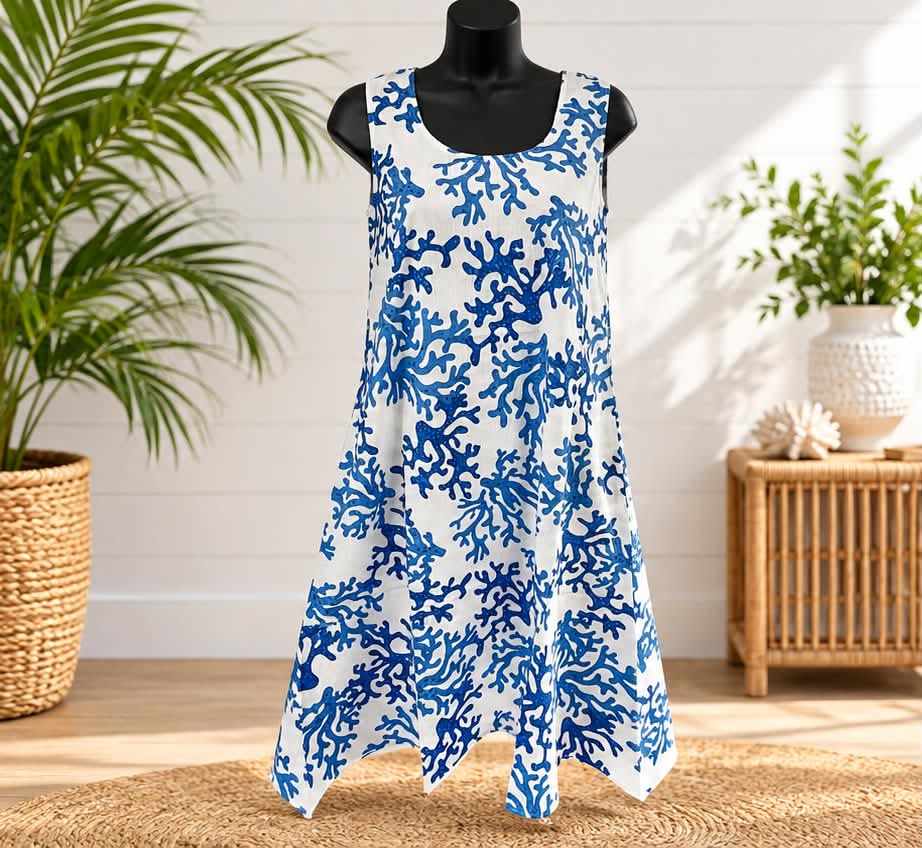 Sleeveless white dress with a blue coral print and a handkerchief hem