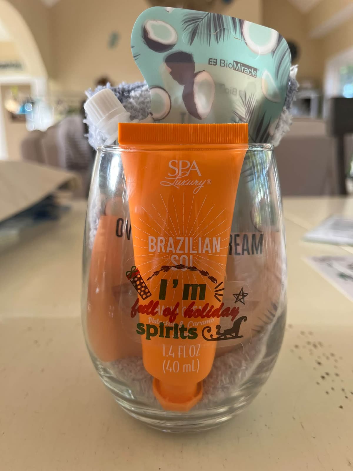 Stemless wine glass gift set with an orange spa cream reading I'm full of holiday spirits