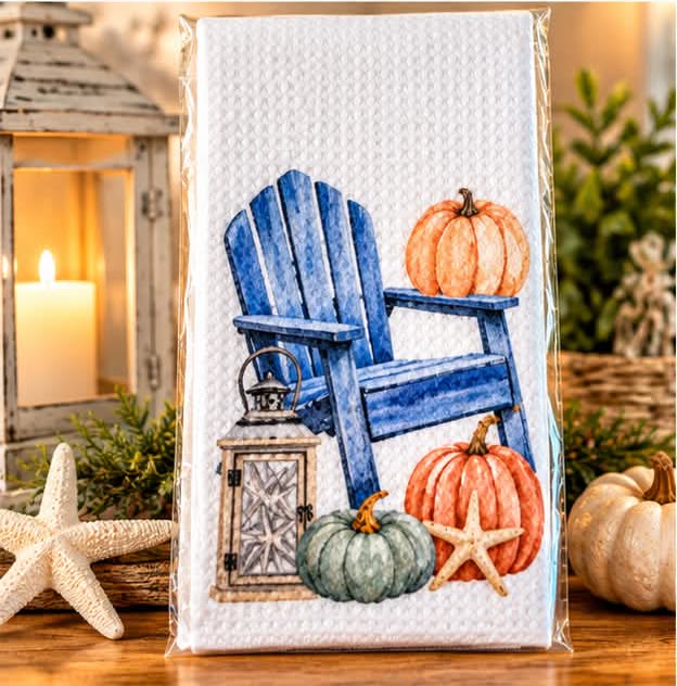 Waffle kitchen towel printed with a palm tree, blue Adirondack chair and pumpkins