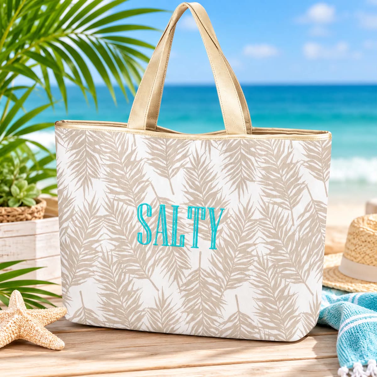 Canvas beach tote with a tan palm leaf print and SALTY embroidered in turquoise